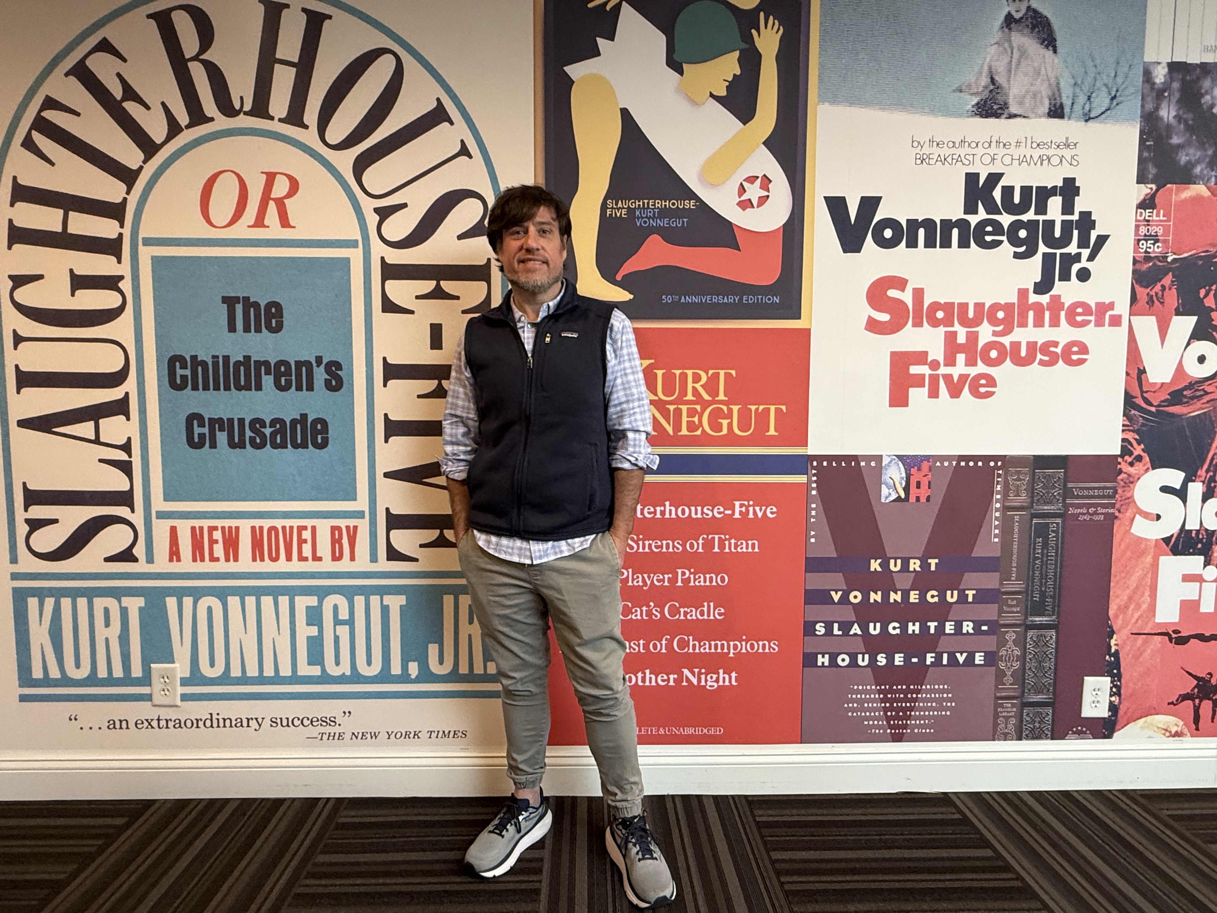 Brian Harris standing in front of Kurt Vonnegut book covers